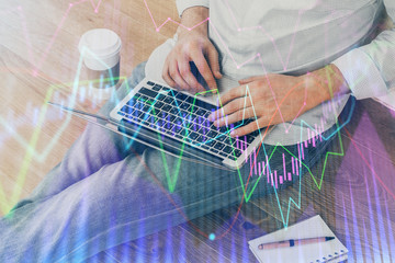 Forex graph with businessman working on computer in office on background. Concept of analysis. Double exposure.