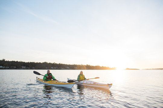 Two people kayaking in the sunshine.