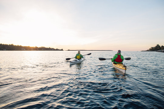 Two people kayaking in the sunshine.