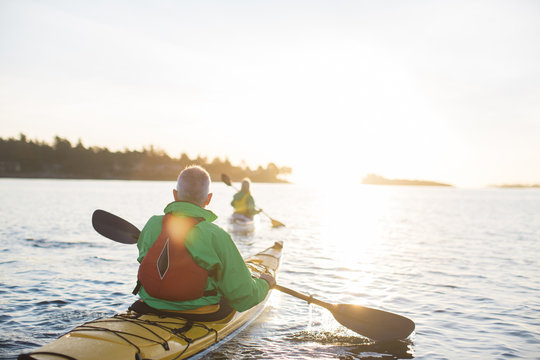 Two people kayaking in the sunshine.