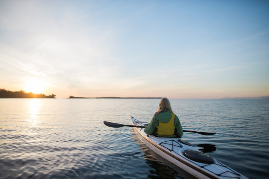 Two people kayaking in the sunshine.