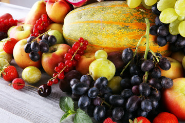 Tropical fruits background, many colorful ripe fruits with strawberries, grapes and cherries on...