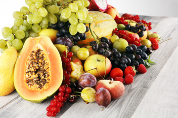 Tropical fruits background, many colorful ripe fruits with strawberries, grapes and cherries on...