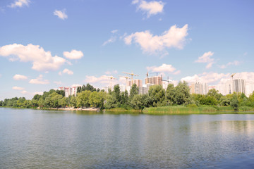 View across the lake to the houses in the city. Landscape outside the city.