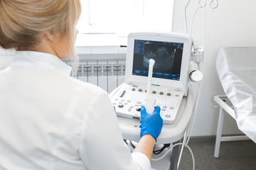 the gynecologist holds the sensor of the ultrasound device with the gel applied in his hand. for inspection of the pelvic organs