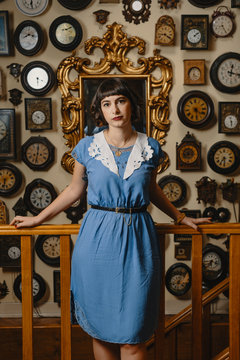 Portrait Of Stylish Woman Wearing Vintage Dress In Front Of The Wall With Clocks
