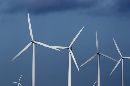 Wind turbines against dark blue sky