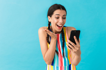 Image of brunette beautiful woman talking on cellphone and expressing surprise