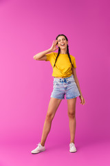 Full length photo of young caucasian woman wearing denim shorts winking and touching her temple