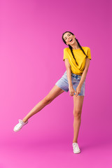 Fototapeta na wymiar Full length photo of young joyful woman wearing denim shorts having fun and dancing