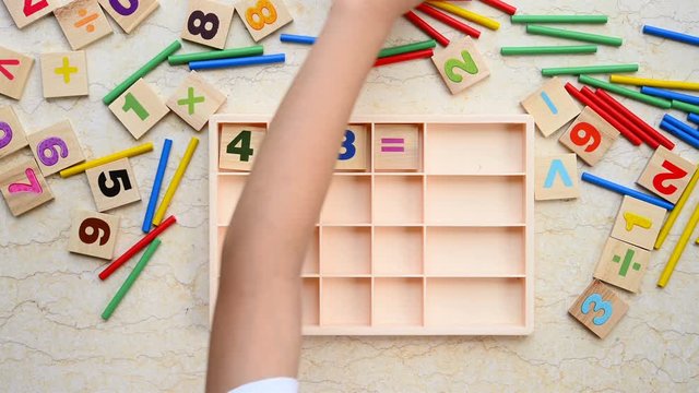 kid doing addition equation using counting rods