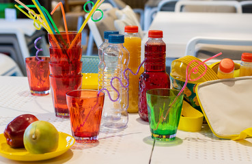Colorful plastic ware and bottle for picnic on table.