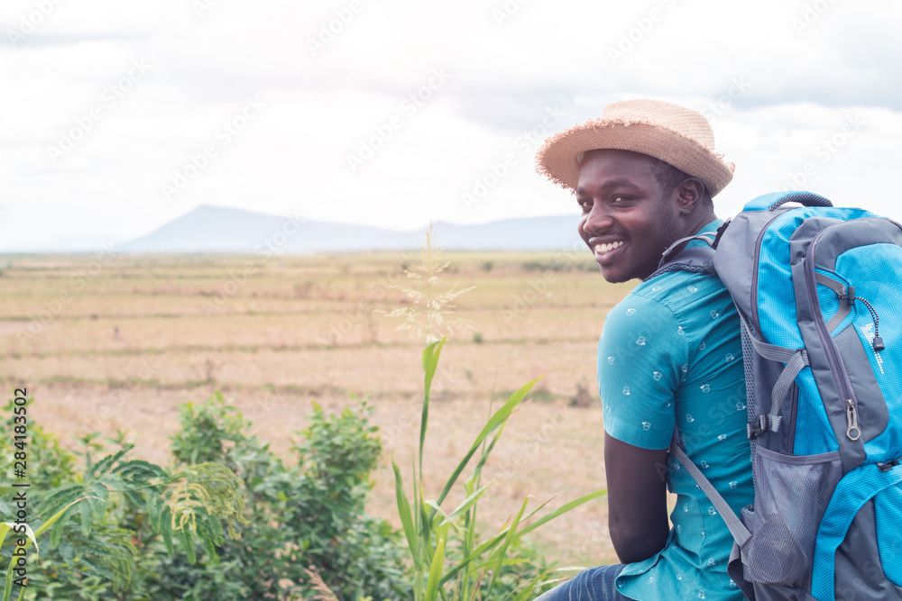 Wall mural African tourist  traveler man with backpack on view of mountain background