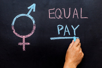 The pay gap and the symbol of gender equality are depicted on the chalkboard. Man's hand with...