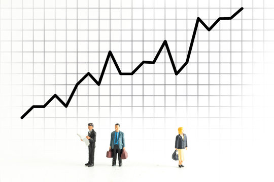 Miniature People Standing Below a Graph Fluctuating up and down