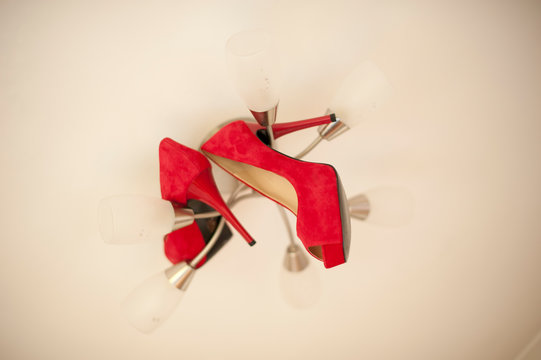 Red Stiletto High Healed Shoes On A Light Fitting