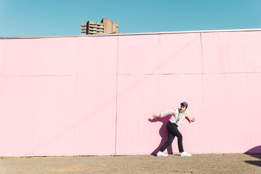 Young man in front of pink construction barrier, traying to escape