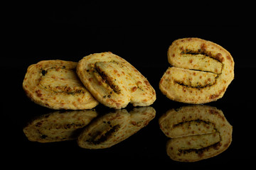 Group of three whole crisp savory cheese palmier isolated on black glass