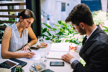 Two businessman using notebook while meeting outdoors