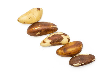 Fototapeta na wymiar Group of five whole unshelled brazil nut in row flatlay isolated on white background