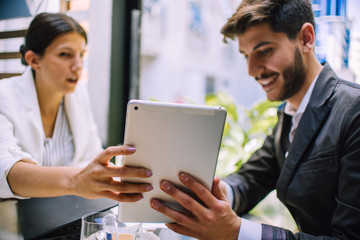 Success businessman couple using tablet pc while meeting in coffee shop