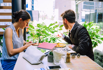 Businessman Interviewing female job applicant In coffee shop