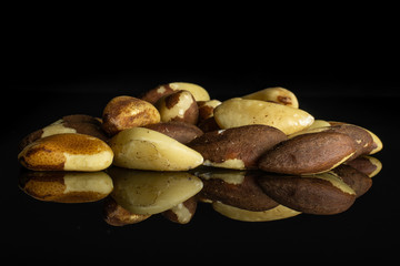 Lot of whole unshelled brazil nut isolated on black glass