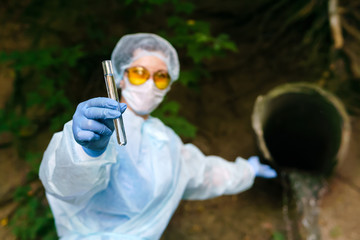 female ecologist or epidemiologist demonstrates a test tube with water, second hand pointing to a...