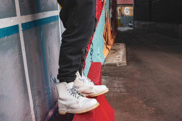 A young man in white boots balancing on EVO traffic barrier