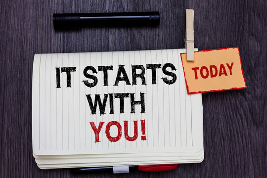 Handwriting text writing It Starts With You. Concept meaning Motivation for starting doing something Have discipline Written paper on wooden desk paper clip grip note with red words black pen