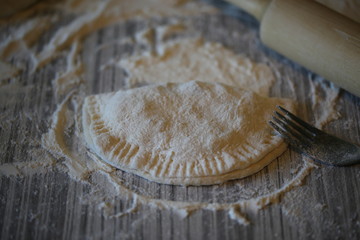 on the table, flour the rolling pin and the hostess prepares pasties