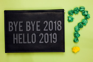 Word writing text Bye Bye 2018 Hello 2019. Business concept for Starting new year Motivational message 2018 is over Green back black plank with text green paper lob form question mark © A