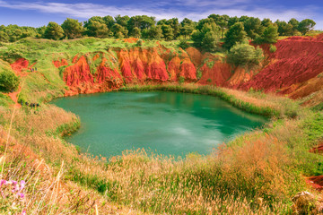 The lake in a old bauxite's quarry in Apulia, Otranto, Salento, Italy.The digging was filled with natural waters. A small lake ecosystem has thus been created, example of spontaneous renaturalization.