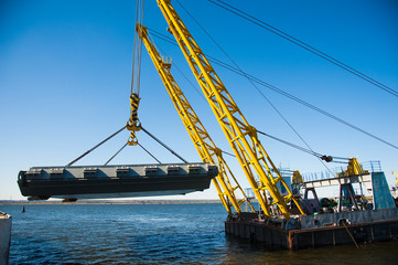 Loading in port. Floating port crane on blue sky background