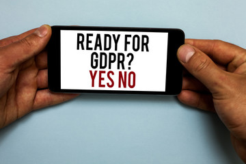 Word writing text Ready For Gdpr question Yes No. Business concept for Readiness General Data Protection Regulation Human hand hold smartphone with red and black letters on shadow blue floor