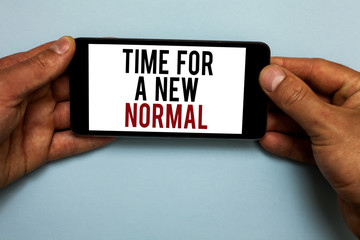 Word writing text Time For A New Normal. Business concept for Make a big dramatic change Replace the expected Human hand hold smartphone with red and black letters on shadow blue floor