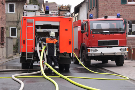 Zwei Feuerwehrfahrzeuge im Einsatz mit Löschrohren