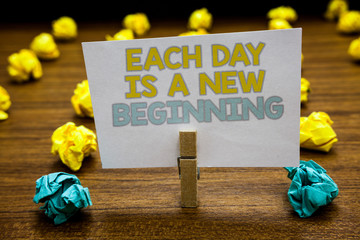 Writing note showing Each Day Is A New Beginning. Business photo showcasing Every morning you can start again Inspiration Written notepad stand with paperclip yellow blue lobs on wooden deck