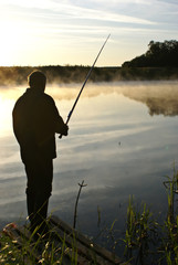 Fisherman in the fog on the river