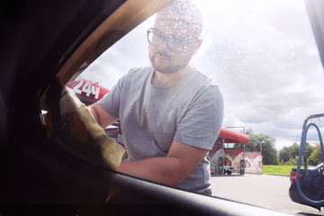 Gomel, Belarus - August 4, 2019: A bearded man in glasses washes silvery car Hyundai Elantra GLS