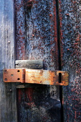 Rusted hinge and hasp with peeling paint