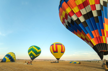 Colorful hot air balloon with blue sky taking off at sunrise