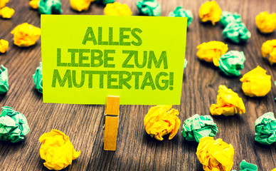 Handwriting text Alles Liebe Zum Muttertag. Concept meaning Happy Mothers Day Love Good wishes Affection Paperclip retain written words yellow paper paper lobs laid on wooden floor