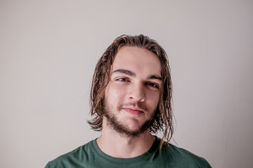 Young attractive guy or boy smiling face expression with wet hair and beard, young man portrait photo