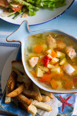 Top view fish soup in a plate in the form of fish and crackers next to a plate, selective focus