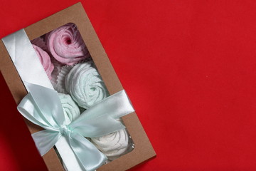 Marshmallows of different colors in gift boxes. Boxes tied with a colored ribbon tied to a bow. View from above.
