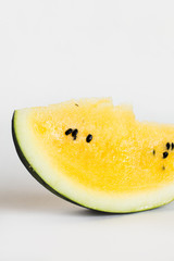 cut a slice of ripe yellow melon on a white background