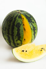 ripe yellow watermelon and sliced watermelon on white background