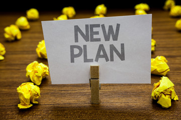 Fototapeta premium Word writing text New Plan. Business concept for Start of a detailed proposal of doing or achieving something Clothespin hold holding paper idea reminder crumpled papers several tries