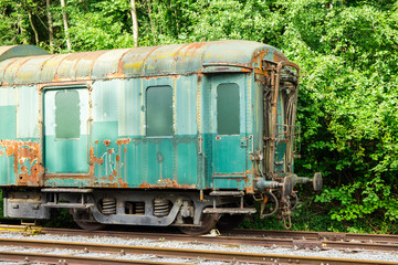 Various rusted wagons and train on the tracks